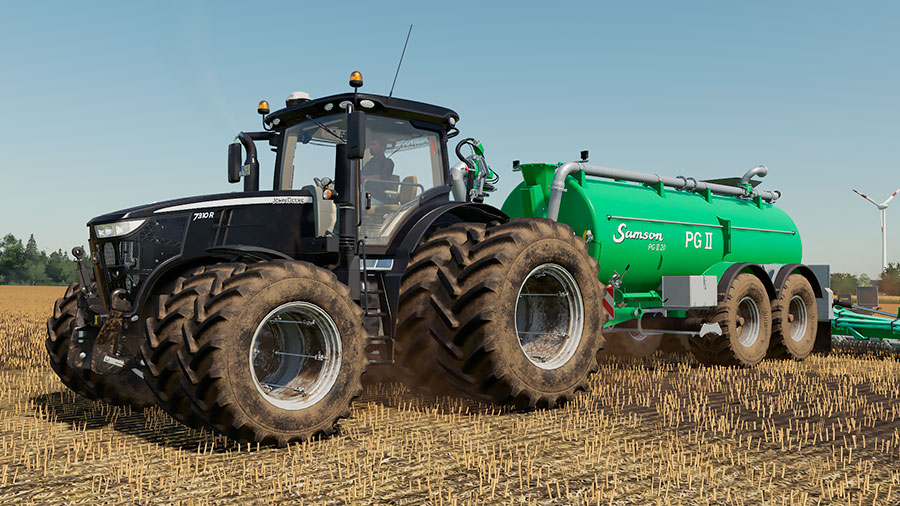 Black John Deere 7R pulling a Samson PG II slurry tanker, injecting slurry into the ground