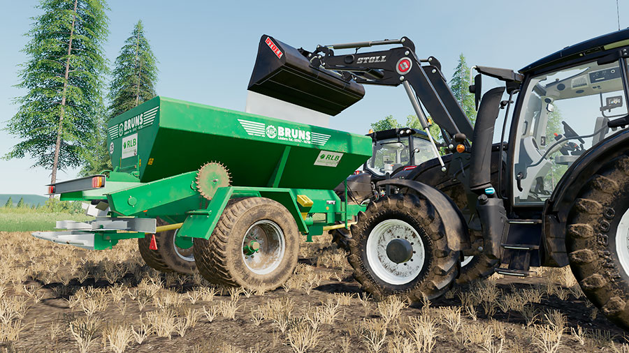 A tractor is filling lime into a Bruns spreader.