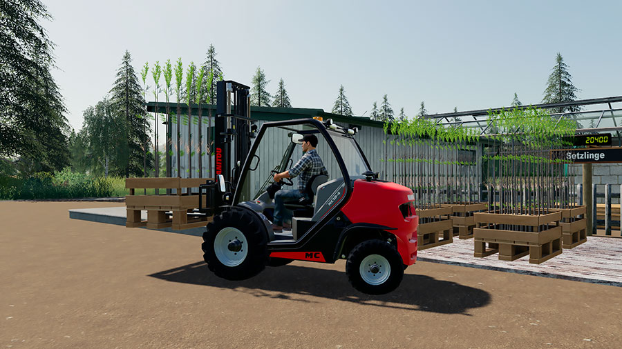 A Manitou forklift is transporting a pallet of tree saplings