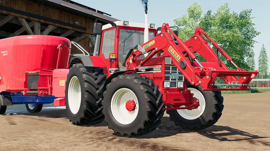 Close up of an International Harvester 1056 XL tractor, with Stoll Robust F30 front loader, pulling a Siloking TMR mixer trailer