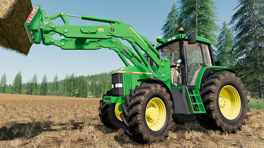 John Deere 6000 Premium with a front loader, lifting a straw bale