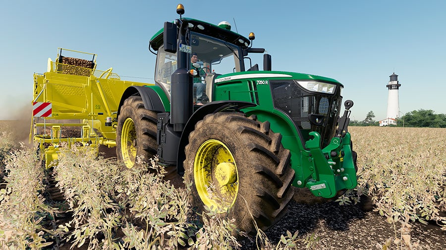 A John Deere 7R, with custom green colors, is pulling a Ropa potato harvester.