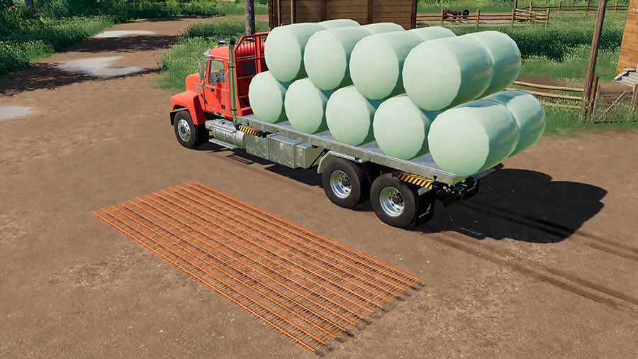 A Mack Pinnacle truck, carrying round bales, is used to demonstrate the unloading marker