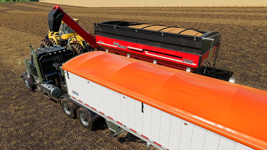 The Wilson trailer about to receive wheat from an Elmer's Haulmaster grain cart